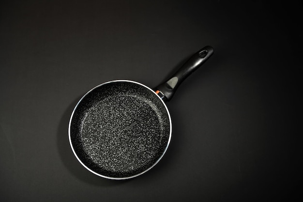 Padella in metallo Rivestimento in ceramica con rivestimento antiaderente Utensili da cucina Su sfondo nero Cucinare per chef in cucinaUn posto per il testoxA