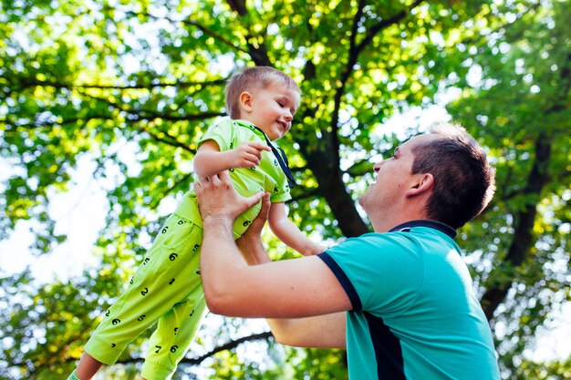 Padre allegro divertendosi con il suo piccolo figlio nel parco.