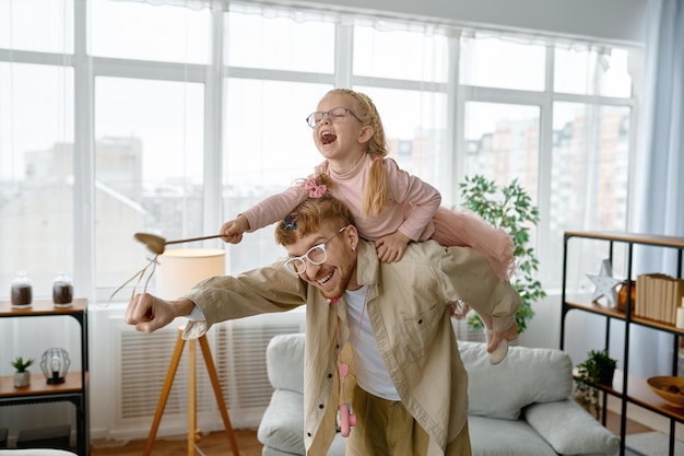 Padre amorevole sulle spalle che guida felice figlia ridente