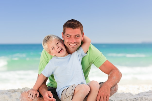 Padre attento con suo figlio in spiaggia