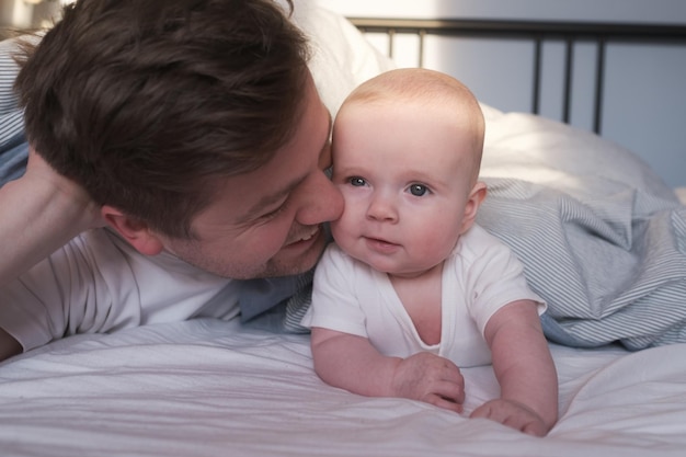 Padre caucasico e bambino carino che riposano insieme a letto.