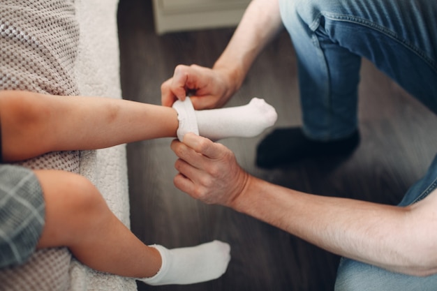 Padre che aiuta la figlia a vestire l'uniforme e la preparazione dei calzini per tornare a scuola.