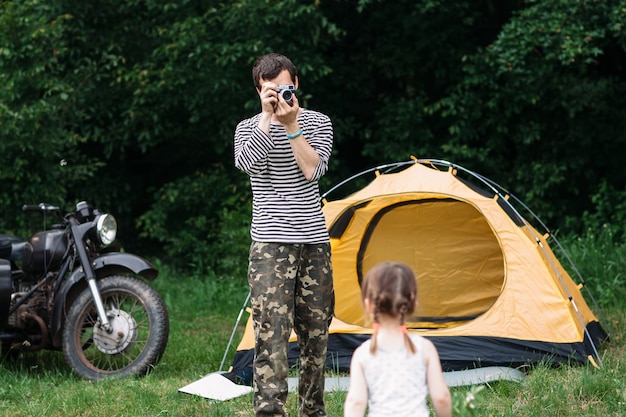 Padre che cattura foto di sua figlia in campeggio