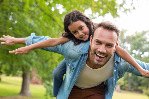 Padre che dà sulle spalle giro alla figlia