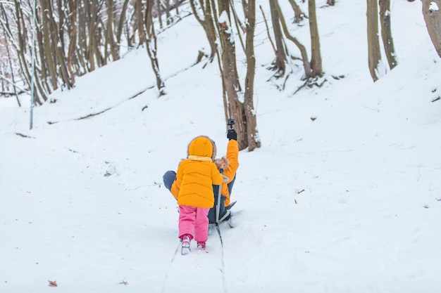 Padre che fa la spola con la ragazza in inverno tirando la slitta