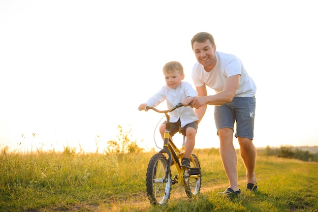 Padre che insegna a suo figlio ad andare in bicicletta