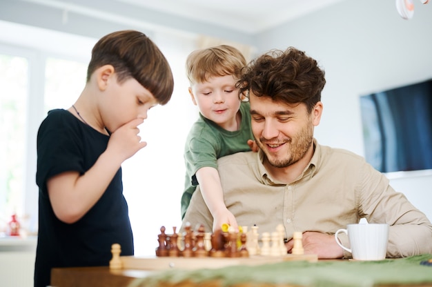 Padre che insegna al figlio a giocare a scacchi Concetto di educazione e insegnamento