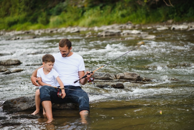 Padre che insegna al figlio come pescare nel fiume