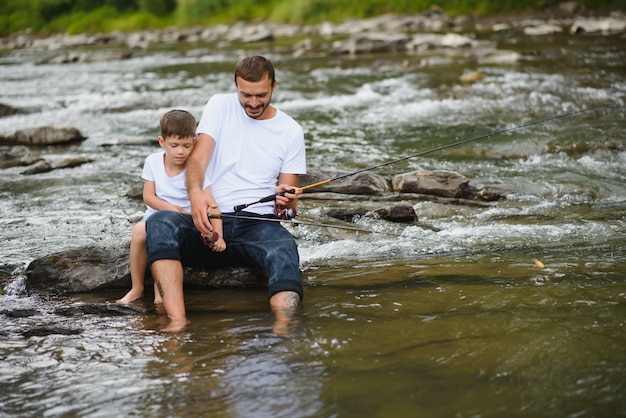 Padre che insegna al figlio come pescare nel fiume