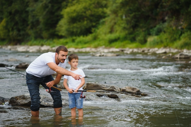 Padre che insegna al figlio come pescare nel fiume