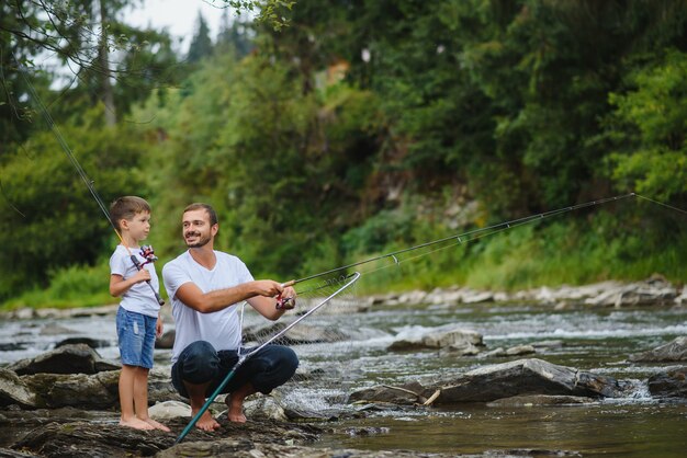 Padre che insegna al figlio come pescare nel fiume