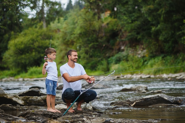 Padre che insegna al figlio come pescare nel fiume