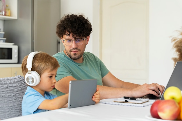 Padre che lavora e tiene la vista laterale del bambino