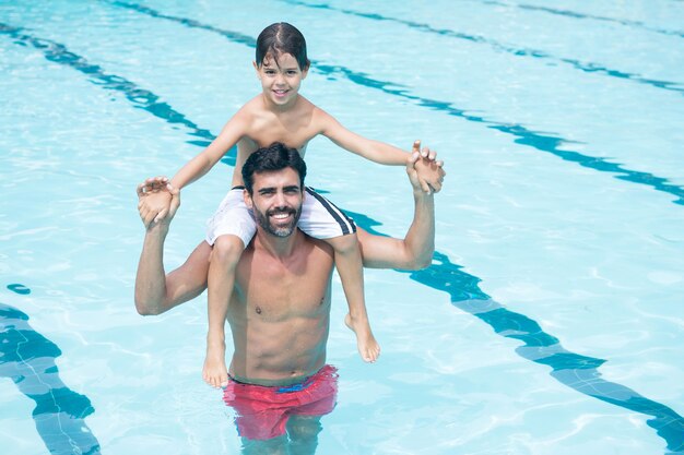 Padre che porta il figlio sulla spalla in piscina