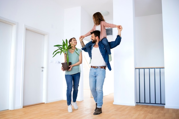 Padre che porta la figlia sulle spalle mentre si trasferisce in un nuovo appartamento.