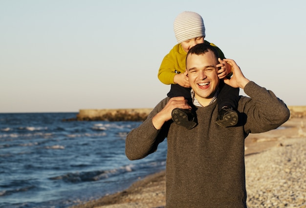 Padre che ride dando a suo figlio un piggy back