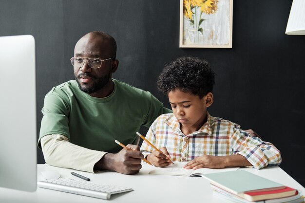 Padre che studia con suo figlio a casa