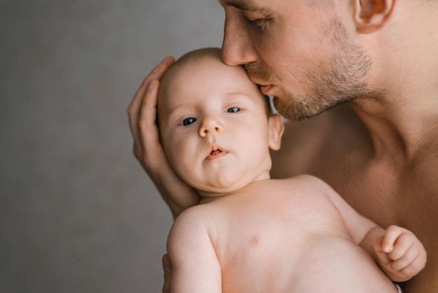 Padre che tiene il suo neonato nelle mani Padre che bacia il suo bambino