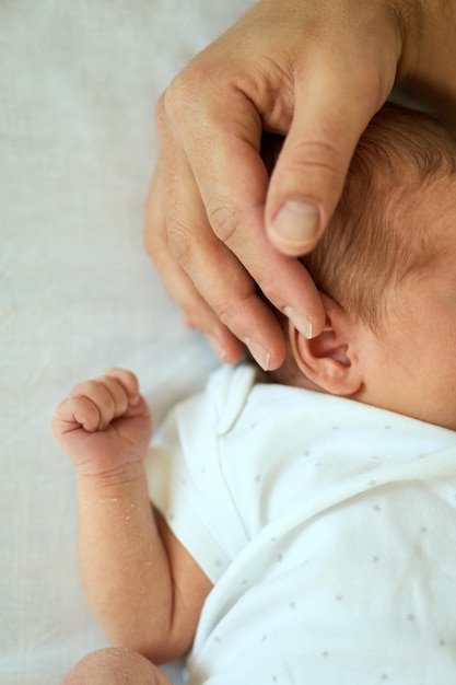 Padre che tiene la testa del bambino addormentato nelle mani sicure