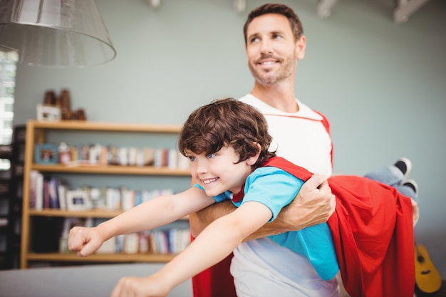 Padre che trasporta il figlio con il costume da supereroe