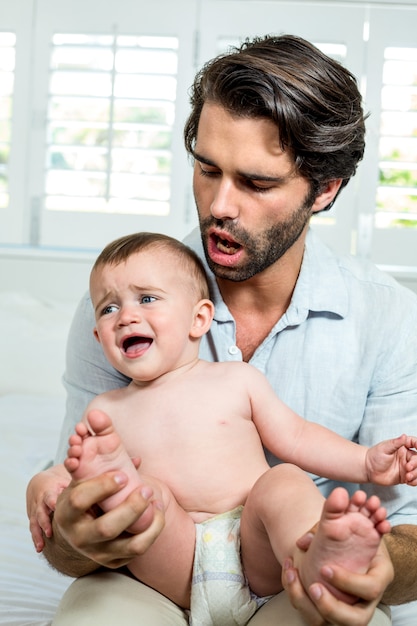 Padre che trasporta pianto bambino