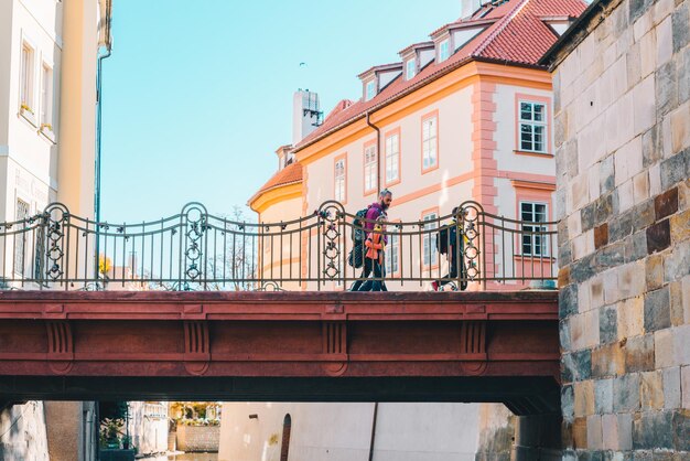 Padre con bambini sul ponte che cammina da qualche parte in una splendente giornata autunnale