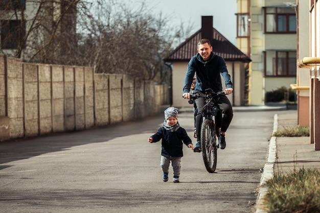 Padre con due bambini in bici