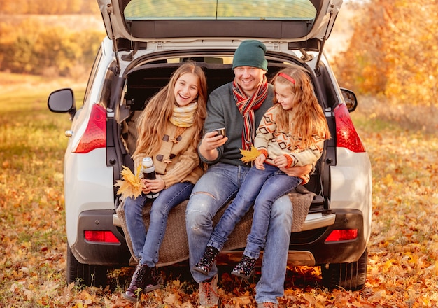 Padre con figlie in un ambiente autunnale