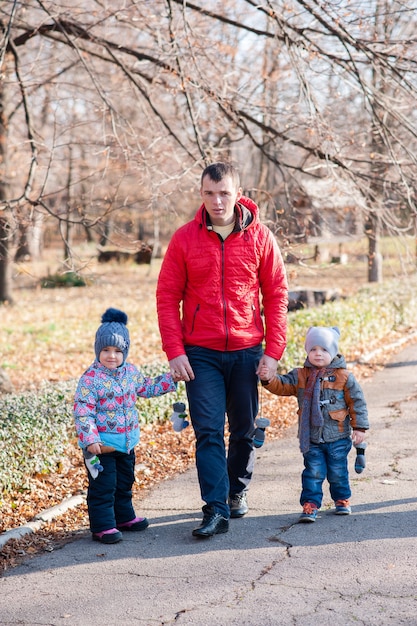 Padre con i bambini che camminano attraverso il parco