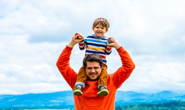 Padre con il figlio che cammina all'aperto con le montagne alle spalle