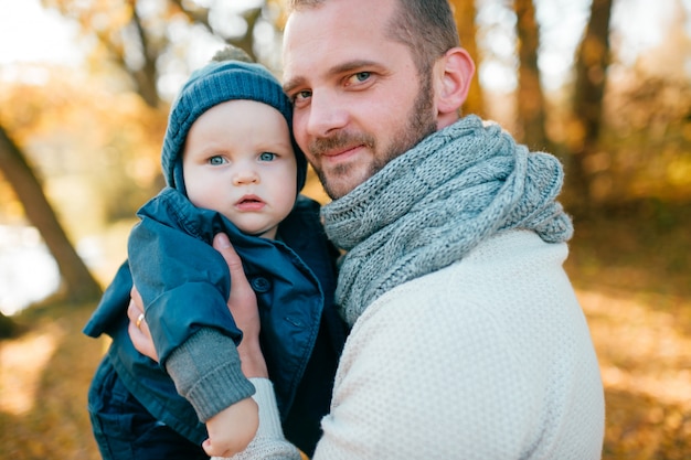 Padre con il piccolo figlio nel parco di autunno