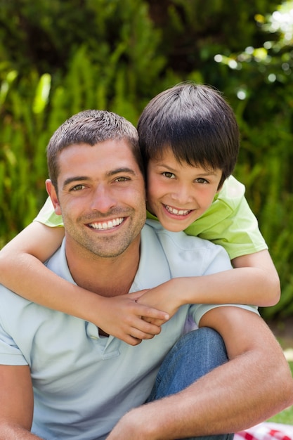 Padre con suo figlio che abbraccia in giardino