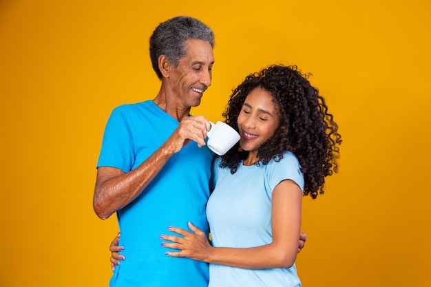 Padre con una tazza di caffè che passa vicino al naso di sua figlia per farle annusare l'aroma. Foto per le campagne del caffè e per la festa del papà