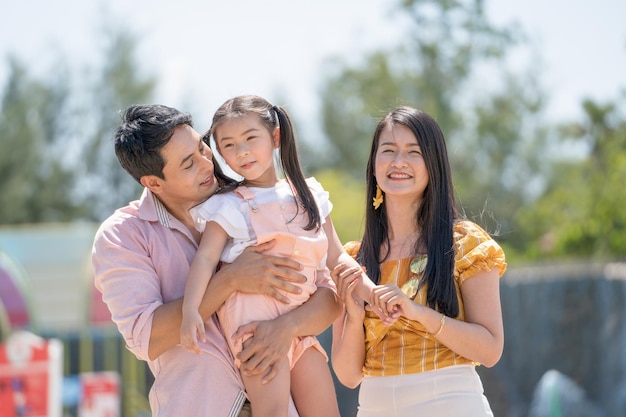 Padre di famiglia asiatico madre e figlia che giocano insieme al parco divertimenti