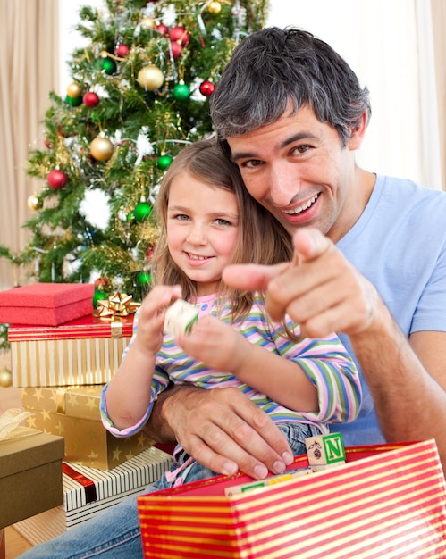 Padre e bambina che giocano con i regali di Natale