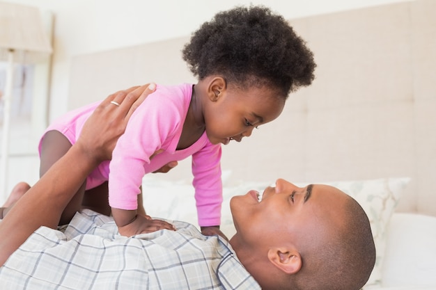 Padre e bambina sdraiata sul letto insieme