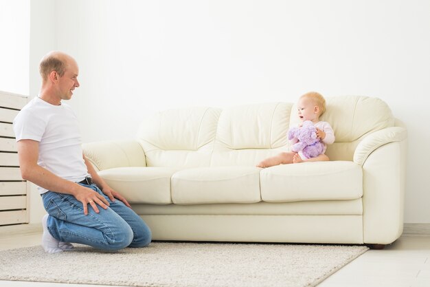 Padre e bambino piccolo bambino al chiuso a casa, giocando