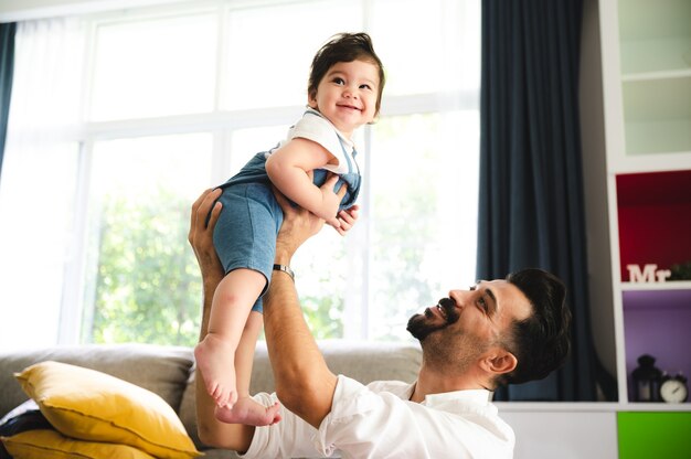 Padre e figli felici insieme a casa, bambino carino con la famiglia dell'infanzia persone che l'uomo sorride e si diverte con il figlio piccolo, amore e cura piccola figlia o stile di vita da ragazzo