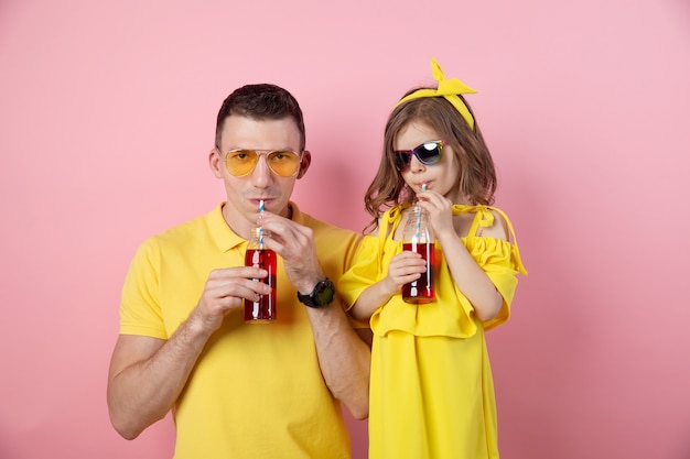 Padre e figlia che bevono le bevande rosse e sorridere