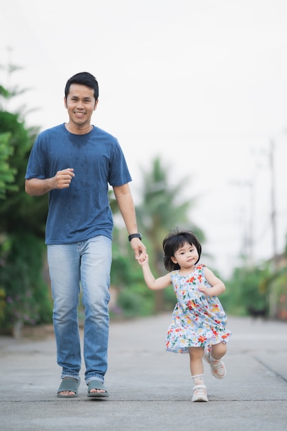 Padre e figlia che corrono per strada, concetto di famiglia