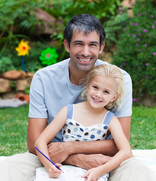 Padre e figlia che dipingono in un parco