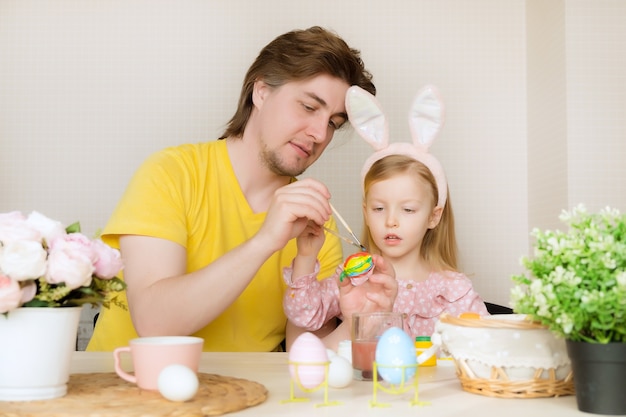 Padre e figlia che dipingono le uova per Pasqua