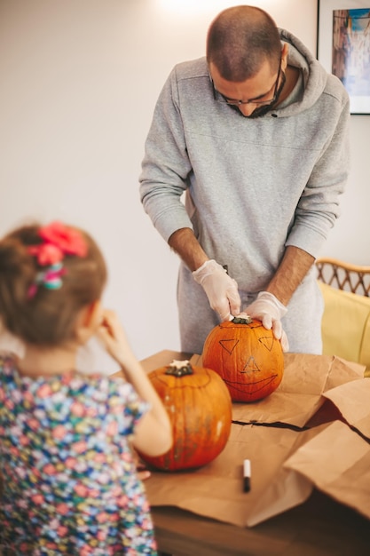 Padre e figlia che intagliano le zucche