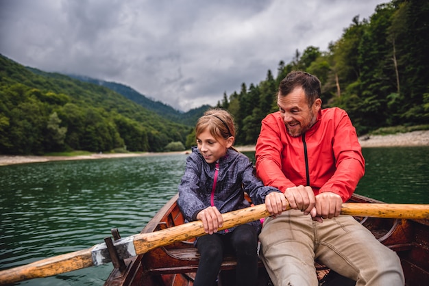 Padre e figlia che remano una barca sul lago