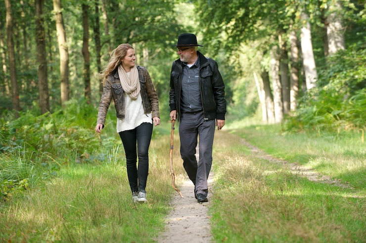 Foto padre e figlia che sorridono e che camminano in natura