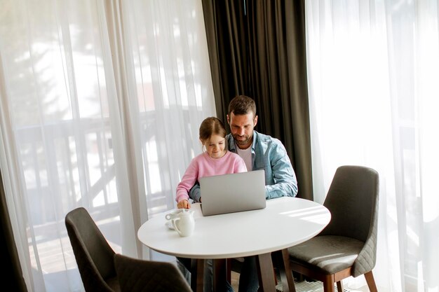 Padre e figlia che utilizzano insieme il computer portatile