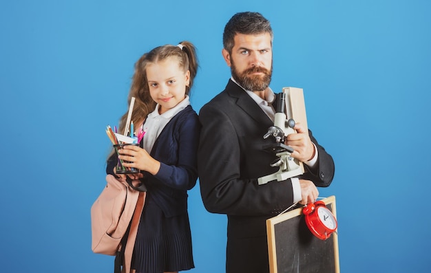 Padre e figlia dell'allievo pronto a scuola Ritratto di papà e bambine con materiale scolastico isol