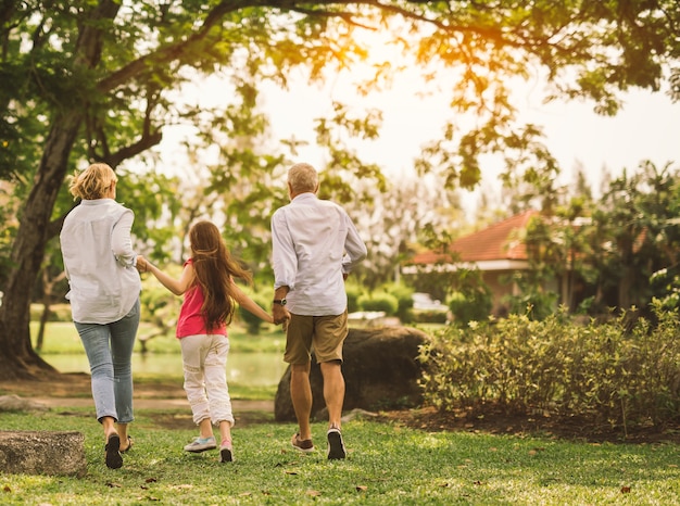 Padre e figlia felici della madre della famiglia che rovinano sulla natura sulla mano della tenuta di tramonto