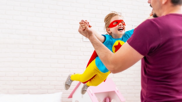 Padre e figlia giocano al supereroe.