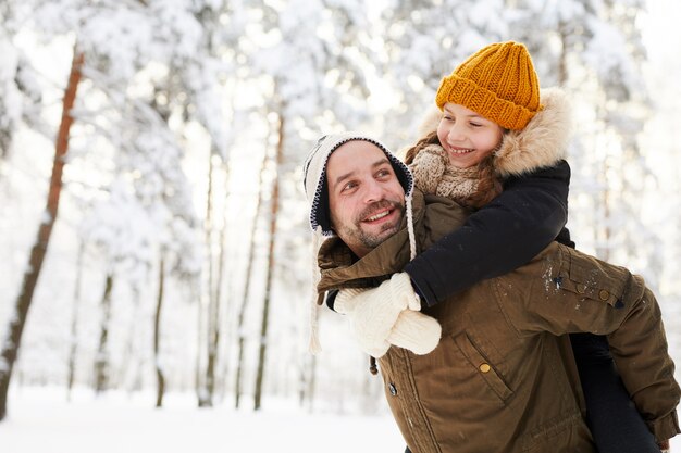 Padre e figlia nella foresta invernale